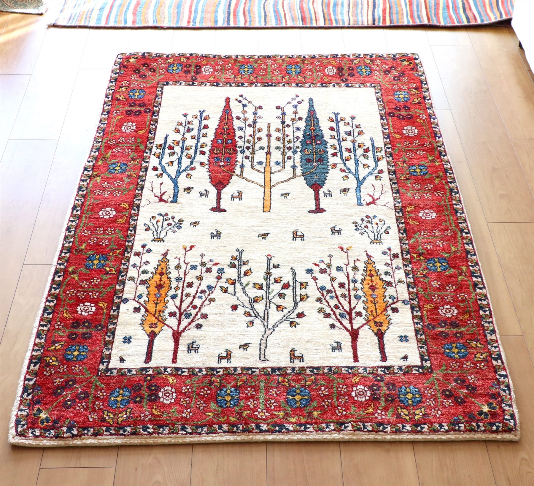 ギャベ ギャッベ・ルリバフ・カシュカイ族の手織りラグ・細かな織りの伝統柄・アクセントラグサイズ 生命の樹と糸杉の周りに動物たち・レッドボーダー